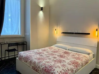 a bedroom with a bed and a table and a window at Room Roma Nazionale in Rome