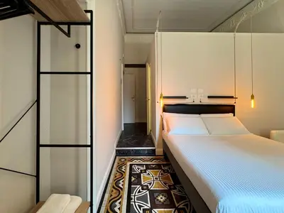 a small room with two beds and a mirror at Room Roma Nazionale in Rome