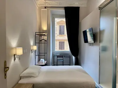 a small bedroom with a bed and a window at Room Roma Nazionale in Rome