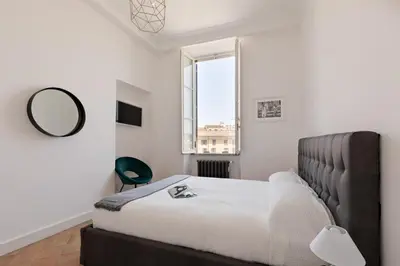 a bedroom with a bed with a mirror and a window at Presidential Penthouse Navona in Rome