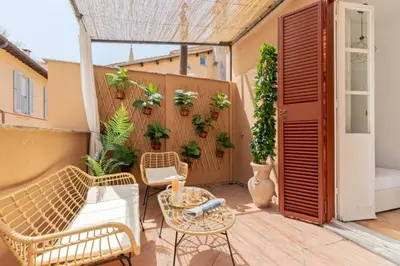 a patio with chairs and a fence with plants at Presidential Penthouse Navona in Rome