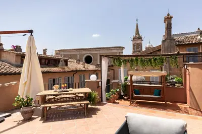 an outdoor patio with a table and a umbrella at Presidential Penthouse Navona in Rome