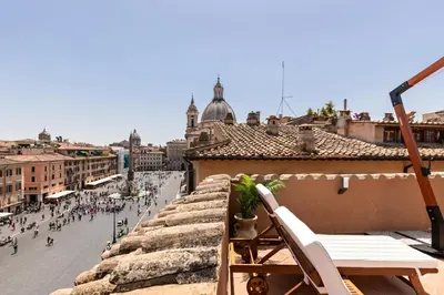 a chair on a balcony of a building with a street at Presidential Penthouse Navona in Rome