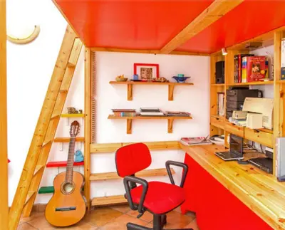 a tiny house with a red chair and a guitar at Charming Studio near the Colosseum in Rome, 45 m² with Balcony in Rome