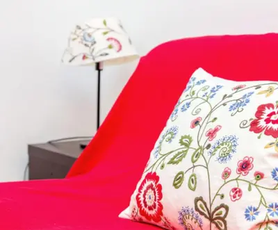 a red chair with a pillow and a lamp at Charming Studio near the Colosseum in Rome, 45 m² with Balcony in Rome