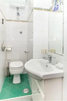 a white bathroom with a toilet and a sink at Charming Studio near the Colosseum in Rome, 45 m² with Balcony in Rome