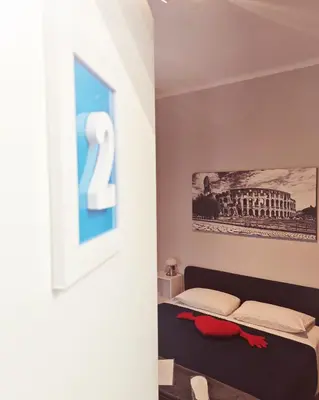 a bedroom with a bed with a number two on the wall at AD Trastevere Guest House - by AD Roma in Rome