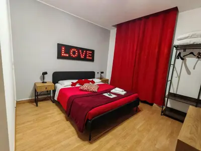 a bedroom with a red bed with a sign that reads love at AD Trastevere Guest House - by AD Roma in Rome