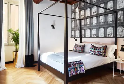a bedroom with a canopy bed with white sheets and pillows at NAMAN HOTELLERIE - Margutta in Rome