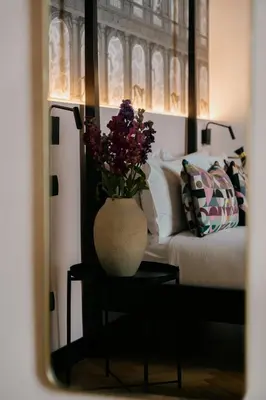 a vase with flowers on a table next to a bed at NAMAN HOTELLERIE - Margutta in Rome