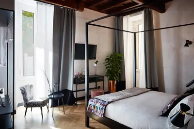 a bedroom with a bed and a table with a vase on it at NAMAN HOTELLERIE - Margutta in Rome