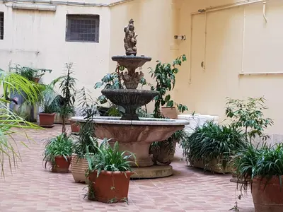 a fountain in a courtyard with potted plants at Vatican Tolemaide 2 in Rome