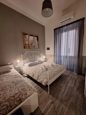 a bedroom with two beds and a window at Vatican Tolemaide 2 in Rome
