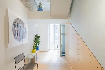 a hallway with white walls and a staircase with a mirror at The Radical Hotel Roma in Rome