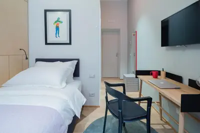a bedroom with a bed and a desk and a chair at The Radical Hotel Roma in Rome