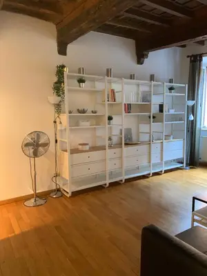 a white book shelf in a living room at Navona Relais - Center of Rome in Rome