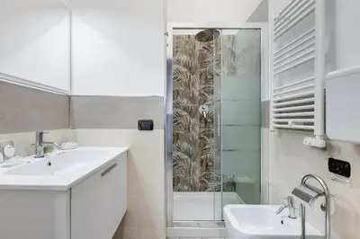 a white bathroom with a shower and a sink at Maison Risorgimento in Rome