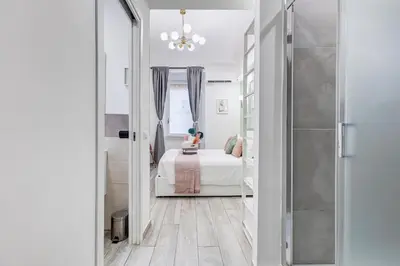 a white room with a bed and a girl sitting on a bed at Maison Risorgimento in Rome