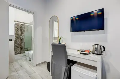 a room with a desk with a sink and a mirror at Maison Risorgimento in Rome