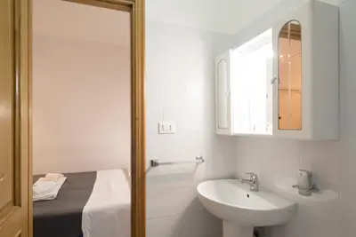 a white bathroom with a sink and a mirror at Magenta Collection Terrione 17 in Rome
