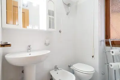 a bathroom with a sink and a toilet and a mirror at Magenta Collection Terrione 17 in Rome