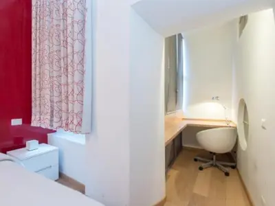 a bedroom with a bed and a window and a chair at Spagna Sistina 143 in Rome