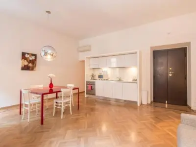 a living room with a table and chairs and a kitchen at Spagna Sistina 143 in Rome