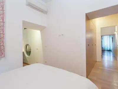 a white room with a bed and a hallway at Spagna Sistina 143 in Rome