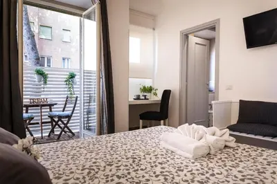 a bedroom with a bed and a balcony with a table at Dulcis In Vatican b&b in Rome