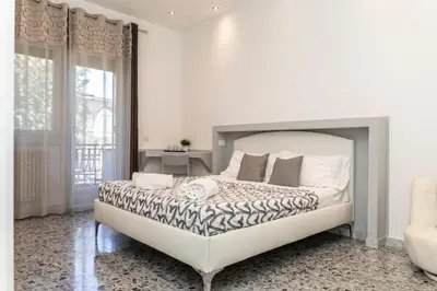 a white bedroom with a large bed and a window at Dulcis In Vatican b&b in Rome