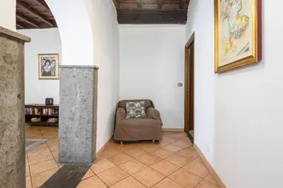 a kitchen with wooden cabinets and a tile floor at Confortevole Appartamento nel Centro Storico con 2 camere AC WiFi in Rome