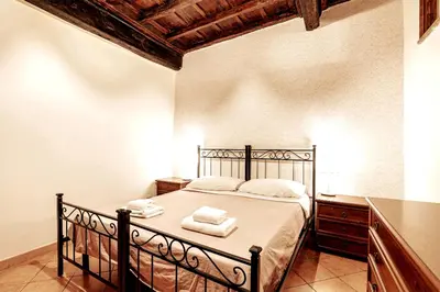 a dining room with a wooden table and chairs at Confortevole Appartamento nel Centro Storico con 2 camere AC WiFi in Rome