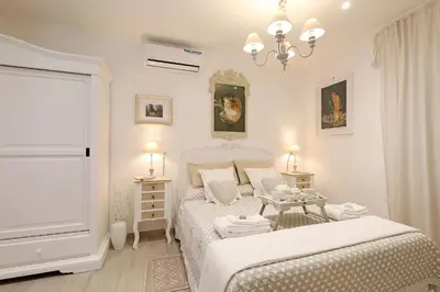 a white bedroom with two beds and a window at Cave98 Apartment in Rome