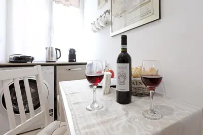 a bottle of wine and two glasses on a table at Cave98 Apartment in Rome