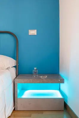 a blue room with a bed and a blue wall at A World Aparts - 87 Boschetto in Rome