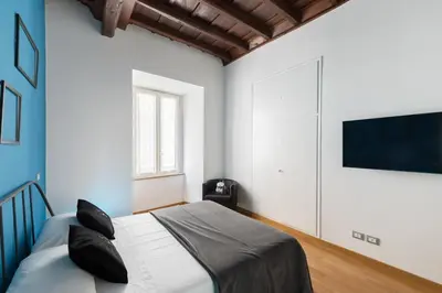 a bedroom with a bed and a flat screen tv at A World Aparts - 87 Boschetto in Rome