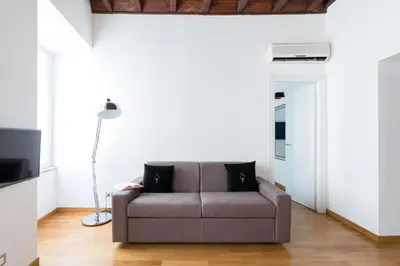 a living room with a couch and a lamp at A World Aparts - 87 Boschetto in Rome