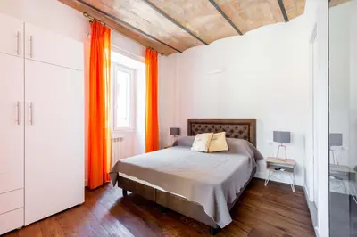 a bedroom with a bed and an orange curtain at Saint Peters Luxury 3 Bedrooms Apartment in Rome
