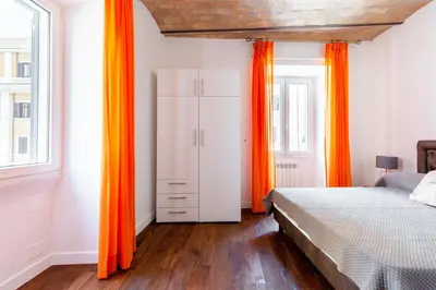a bedroom with orange curtains and a bed at Saint Peters Luxury 3 Bedrooms Apartment in Rome