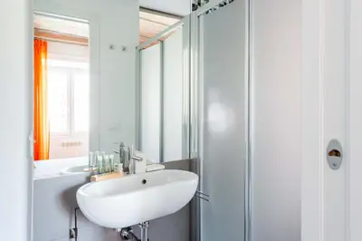 a white bathroom with a sink and a shower at Saint Peters Luxury 3 Bedrooms Apartment in Rome