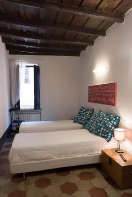 a bedroom with two beds and a wooden ceiling at Casa Nora in Rome