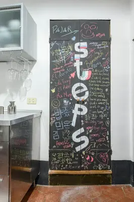 a wall with writing on it in a kitchen at Casa Nora in Rome