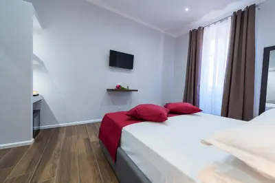 a bedroom with a large white bed with red pillows at Rent Rooms Trastevere in Rome