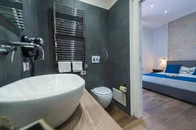 a bathroom with a tub and a bedroom with a bed at Rent Rooms Trastevere in Rome