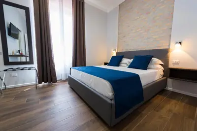 a bedroom with a large bed with blue pillows at Rent Rooms Trastevere in Rome
