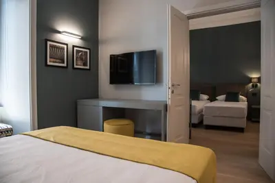 a bedroom with a bed and a tv on a wall at Domus Alberico in Rome