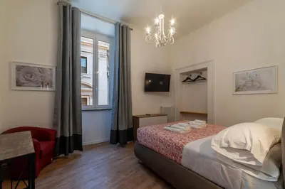 a bedroom with a bed and a window and a chandelier at CS Termini Nazionale Apartments in Rome