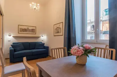 a living room with a table and a blue couch at CS Termini Nazionale Apartments in Rome