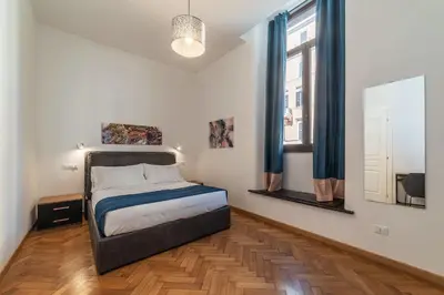 a bedroom with a bed and two windows at CS Termini Nazionale Apartments in Rome