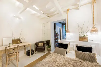 a living room with white walls and a table and chairs at Trastevere Gem Cozy Light-filled Retreat in Rome
